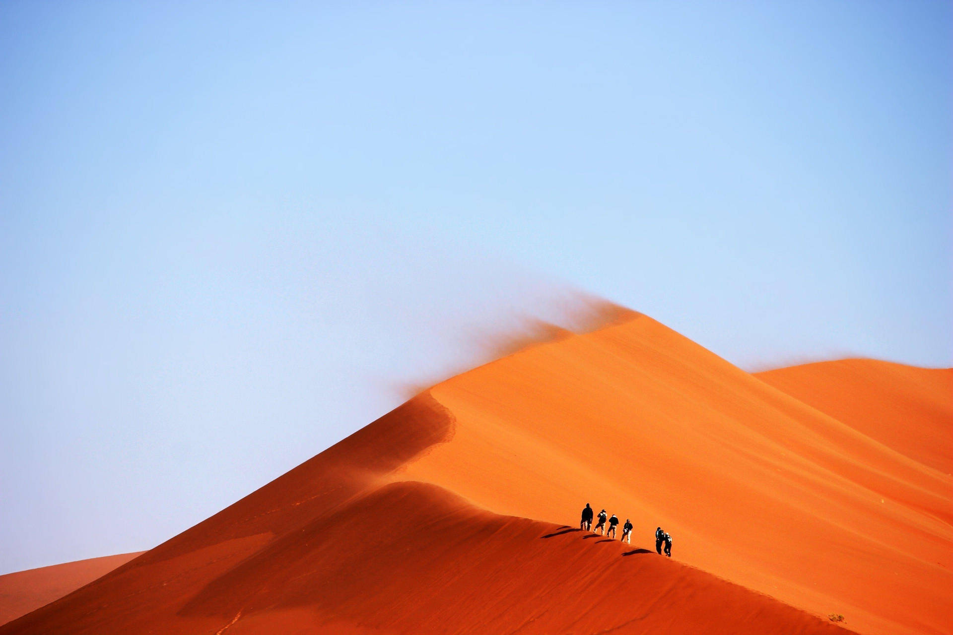 1) A Group Of People Seeking Adventure, Braving The Elements In A Windy Desert! Background