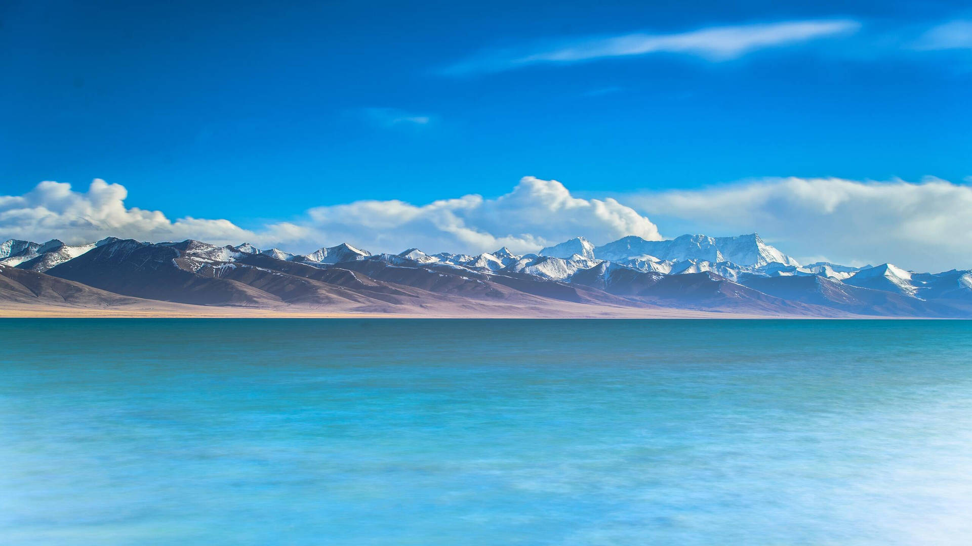 2560 X 1440 Mountain Range By The Sea Background
