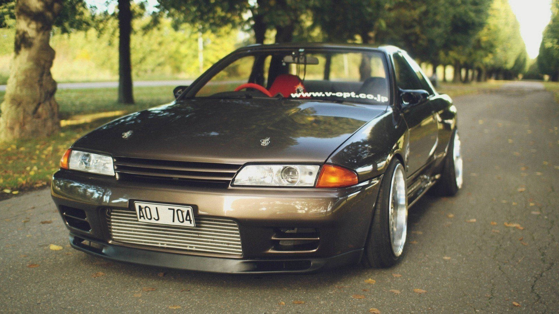 4k Jdm Nissan Skyline Beside Trees Background