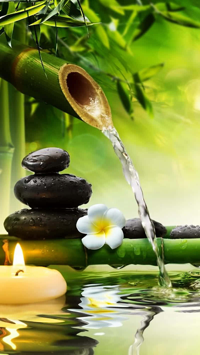 A Bamboo Tree With Water Flowing Over It And Candles Background