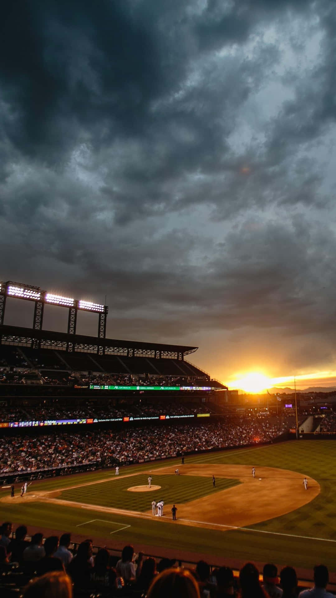 A Baseball Game With A Dark Sky And Clouds