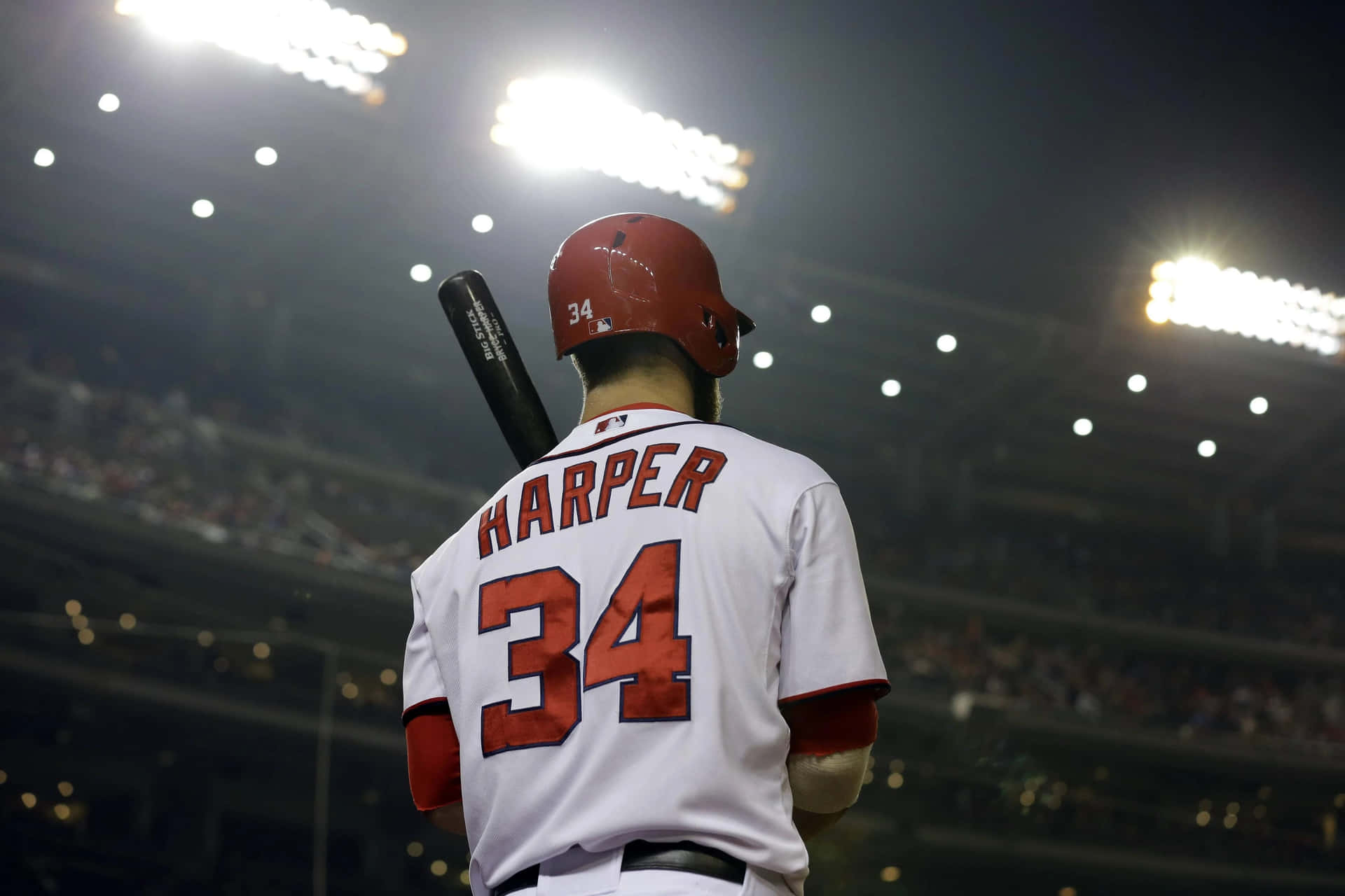 A Baseball Player Is Holding A Bat Background