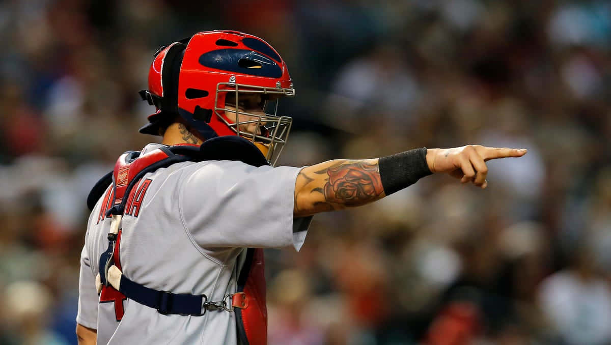 A Baseball Player Pointing To The Field Background