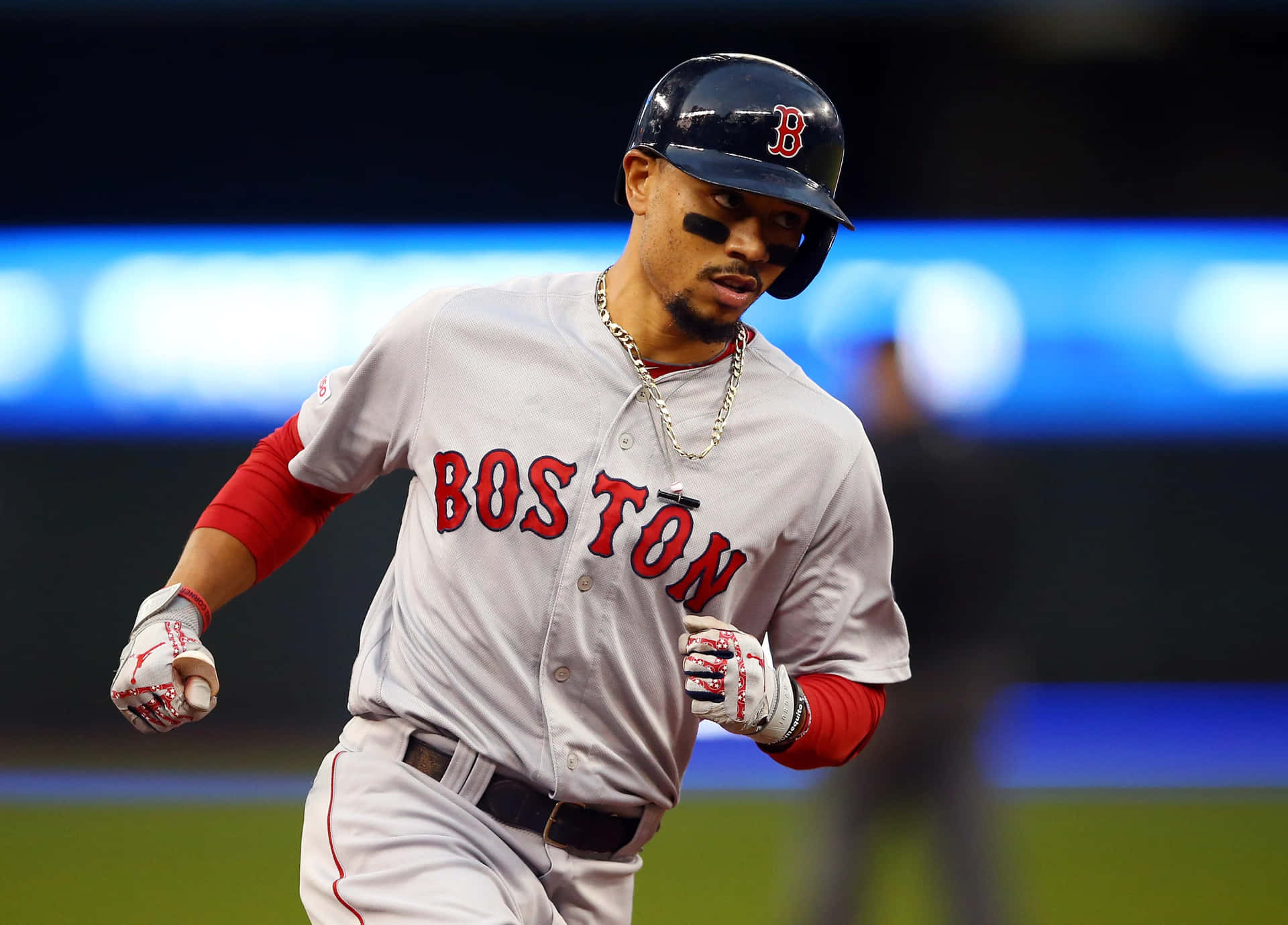 A Baseball Player Running On The Field Background