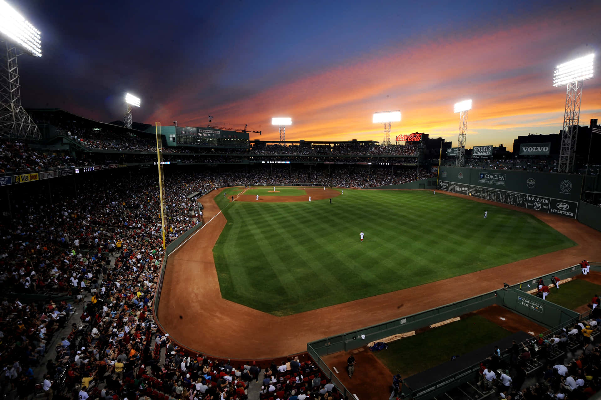 A Baseball Stadium At Sunset Background