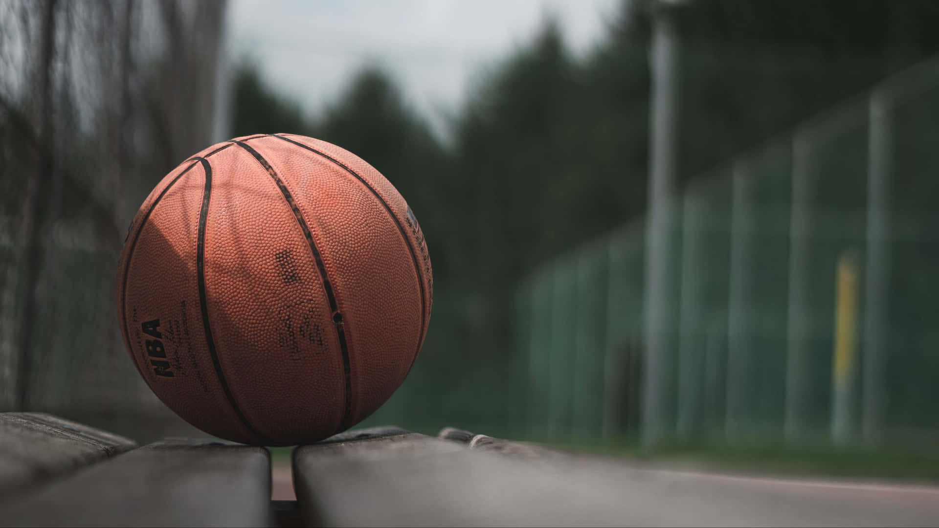 A Basketball Court Lit Up At Night Background