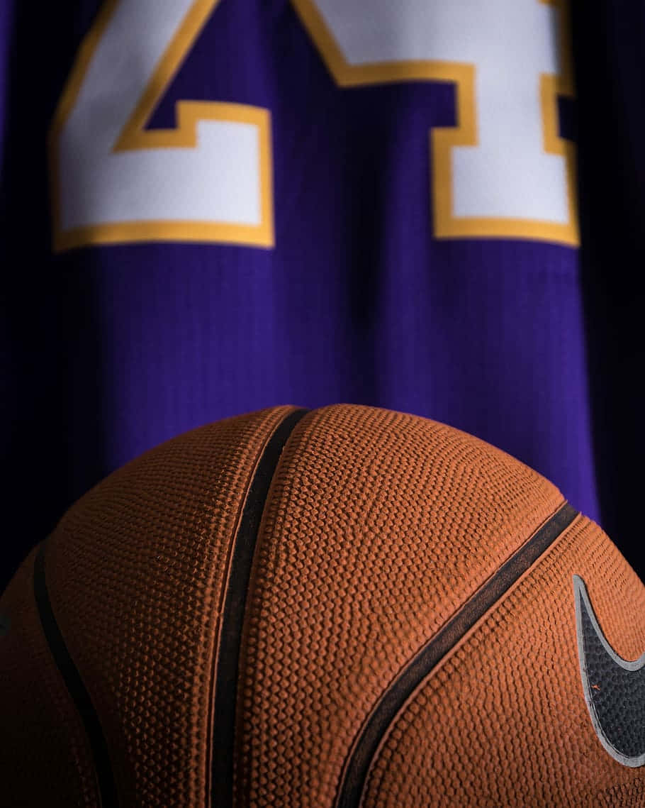 A Basketball Is Sitting On A Purple Jersey