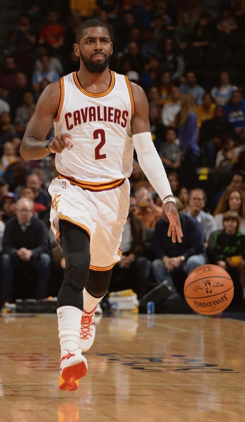 A Basketball Player Is Dribbling The Ball On The Court Background