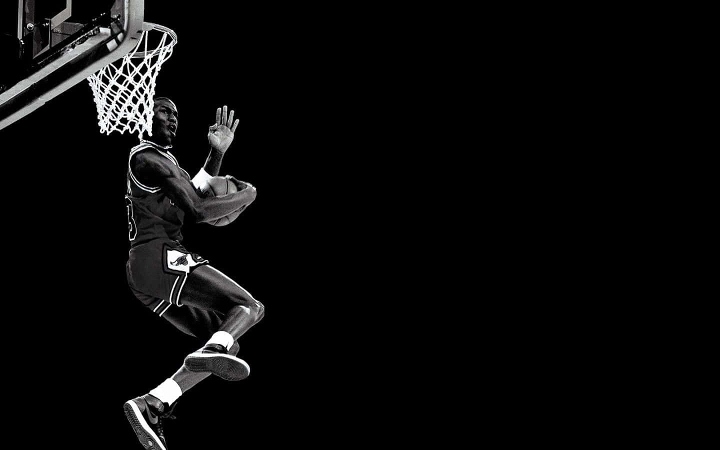 A Basketball Player Is Dunking The Ball In Black And White Background