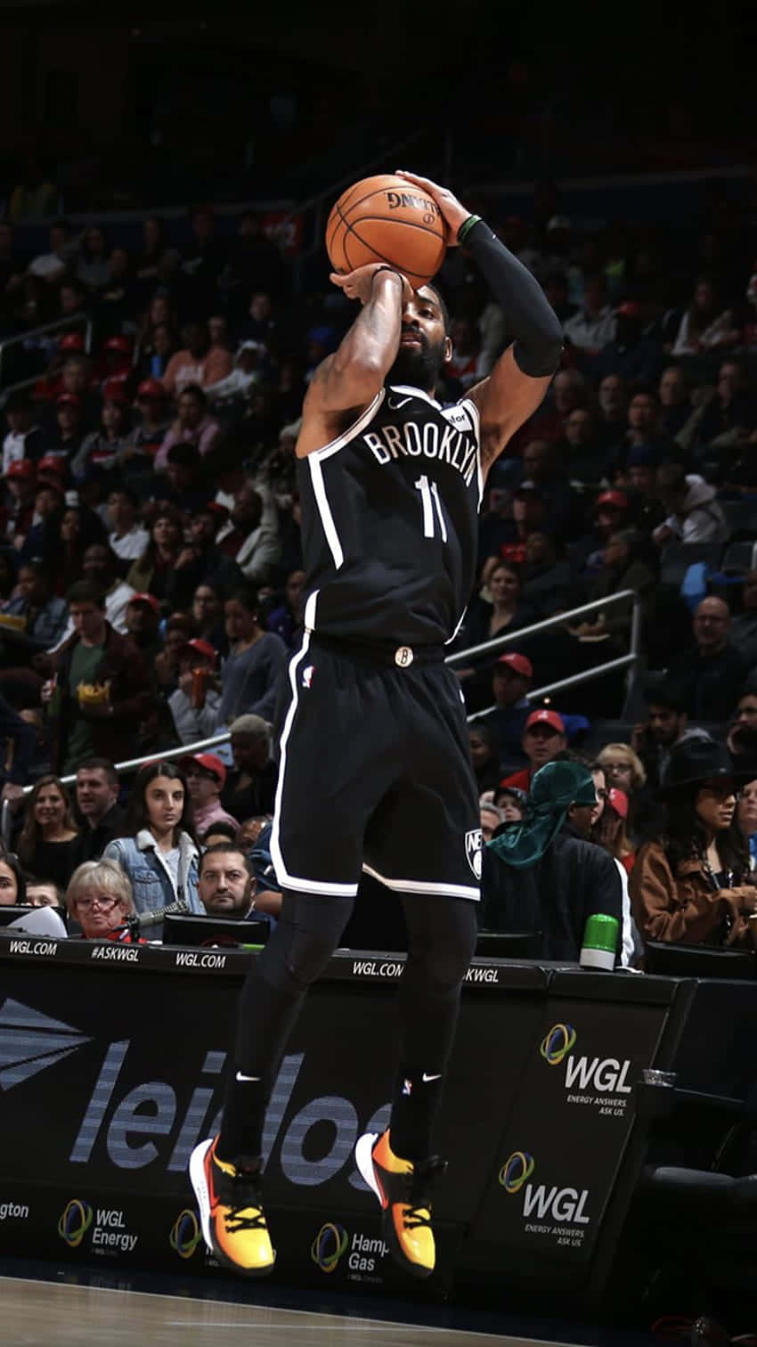 A Basketball Player Is In The Air While Dribbling Background