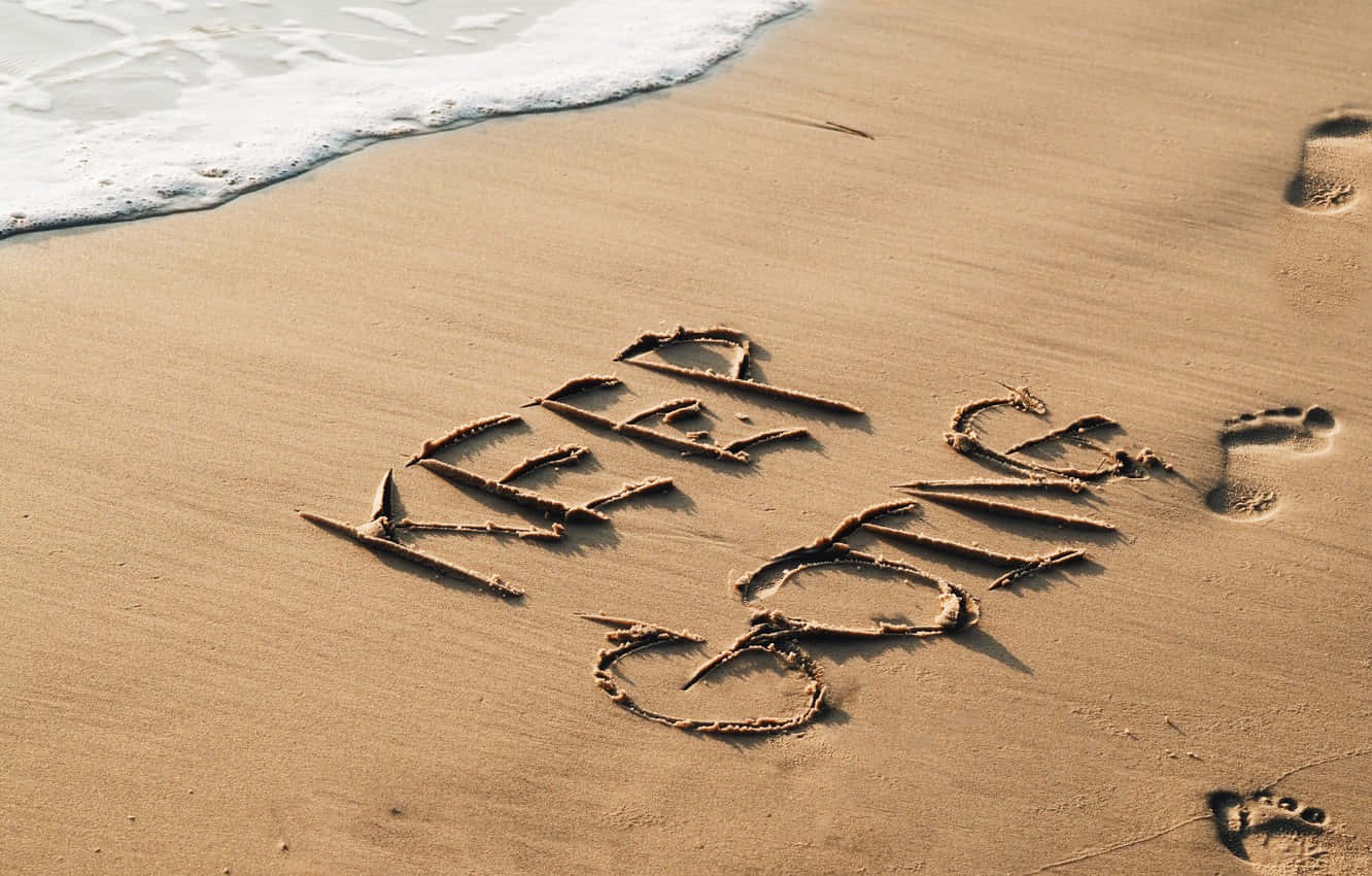 A Beach With A Word Written In The Sand Background