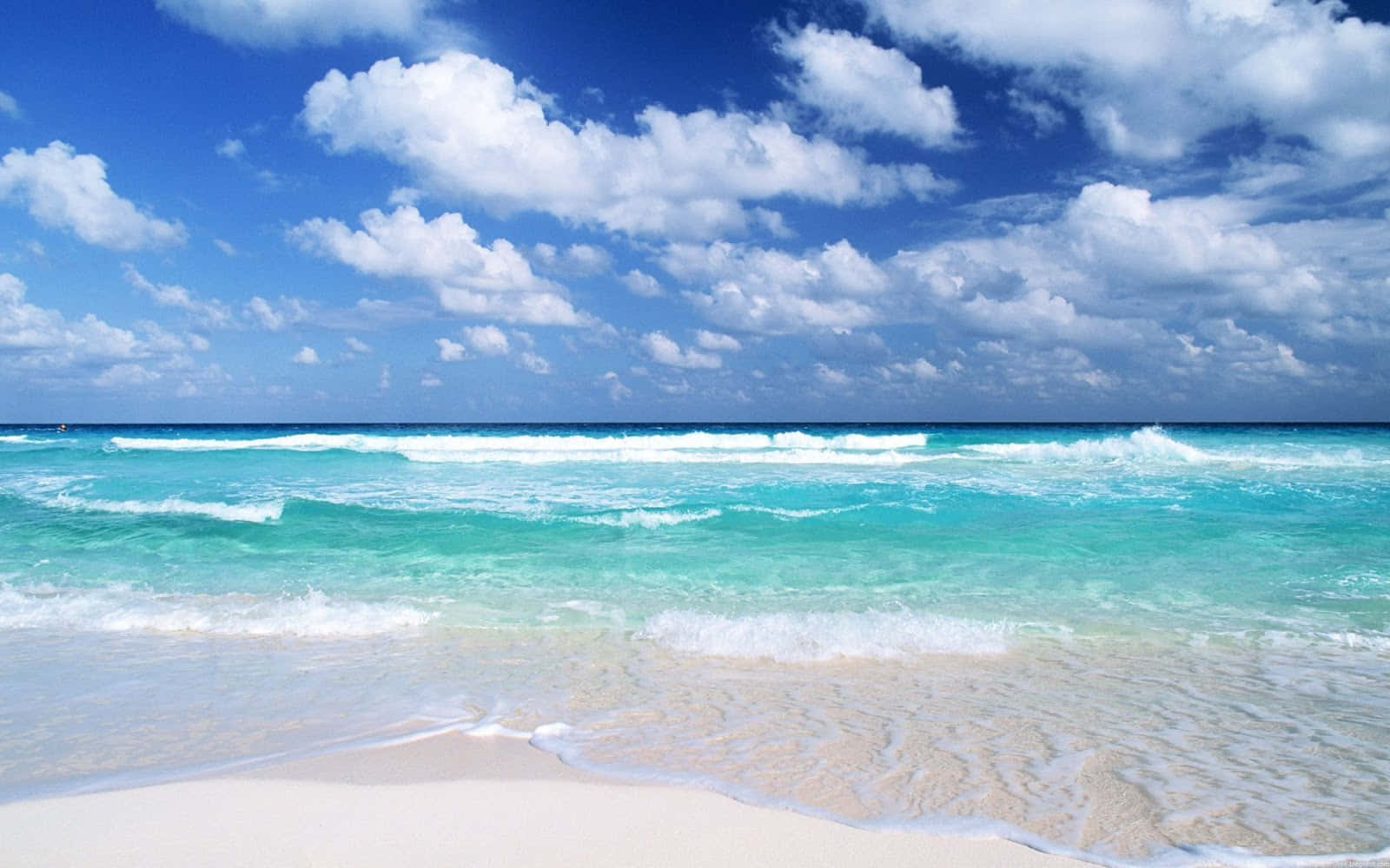 A Beach With Blue Water And White Clouds Background