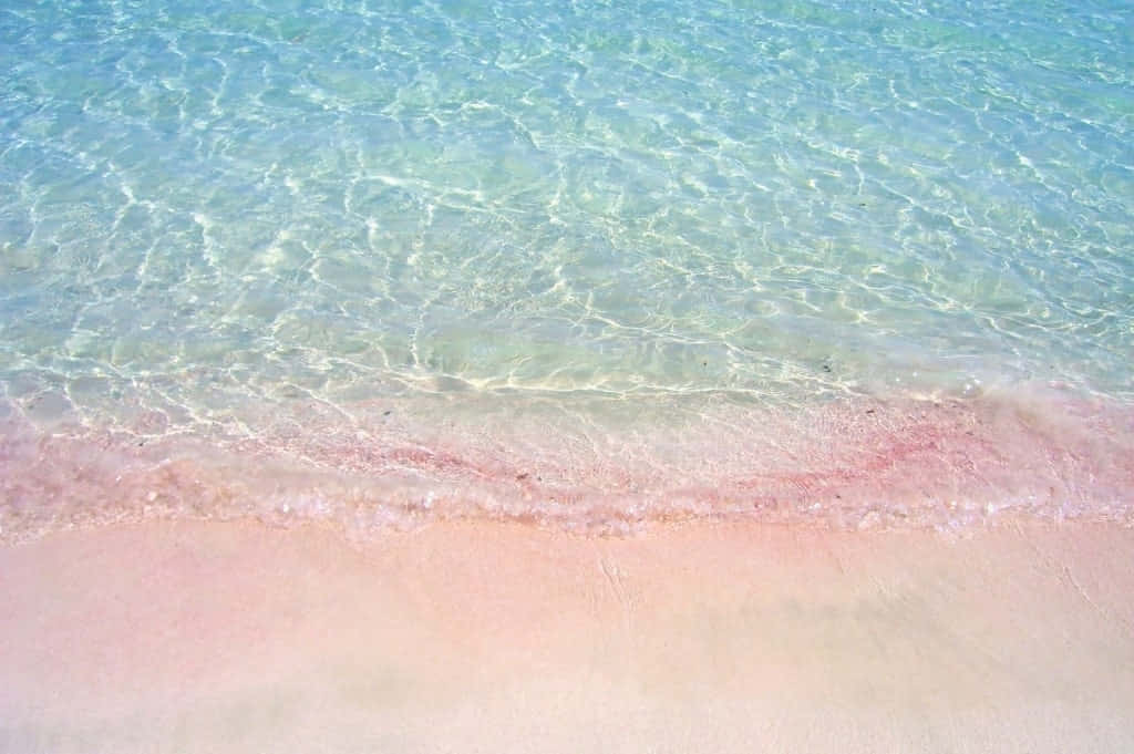 A Beach With Pink Sand And Water Background