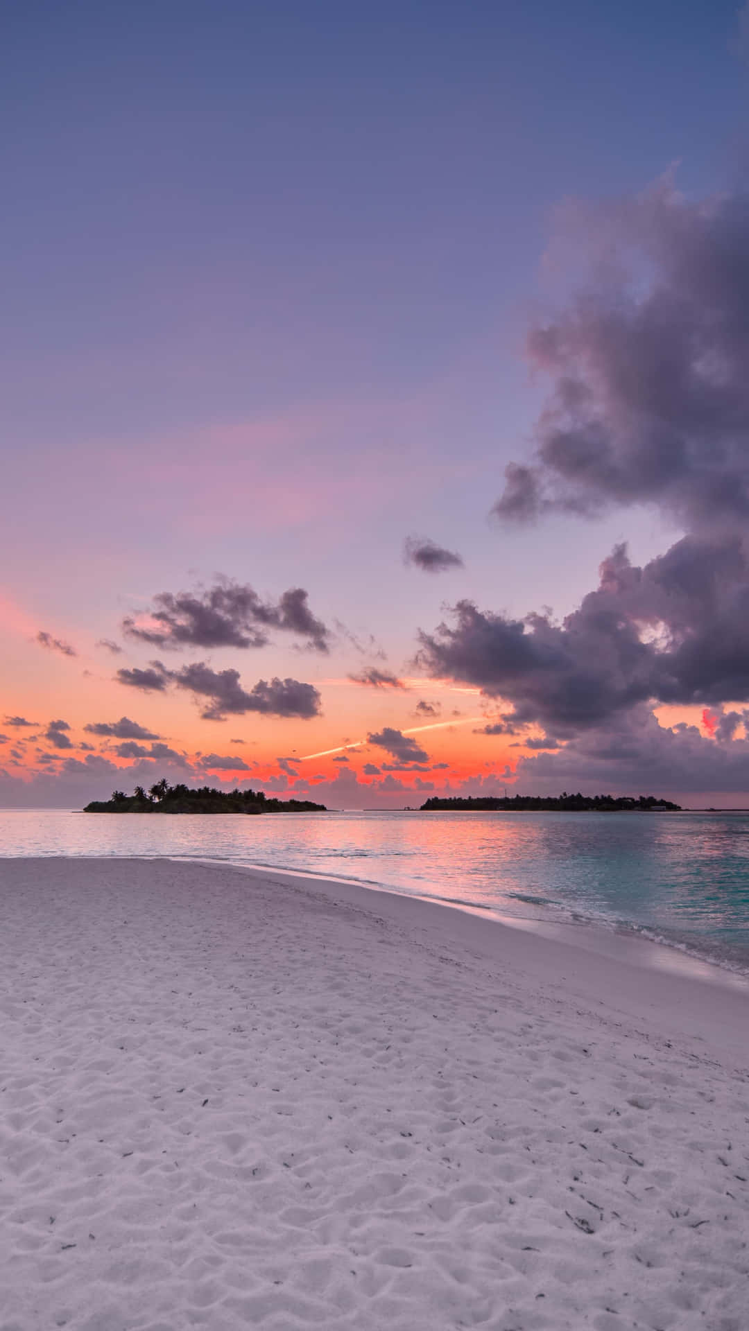 A Beach With Sand And Water At Sunset Background
