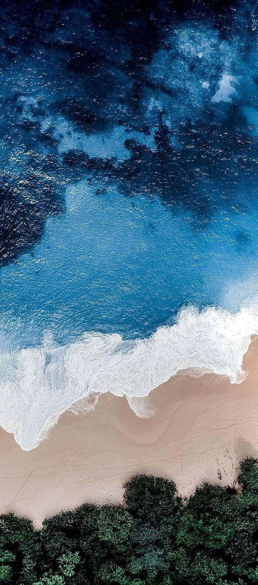 A Beach With Waves And Trees In The Background Background