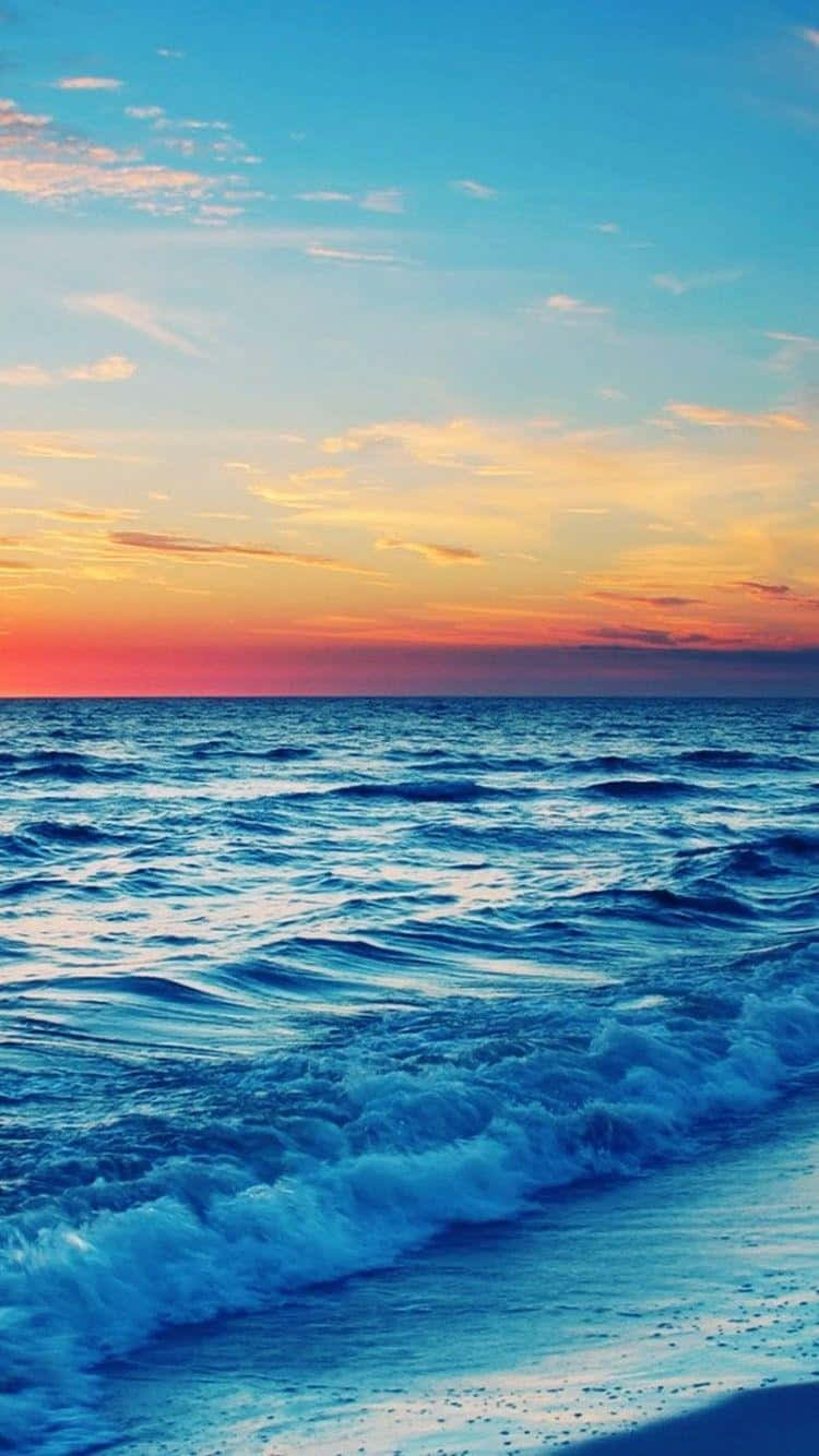 A Beach With Waves At Sunset Background