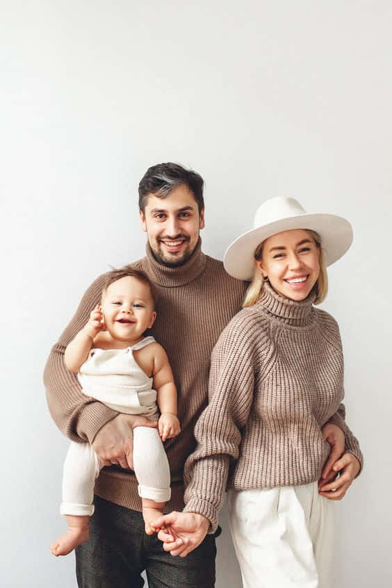 A Beautiful Smiling Family Stands Together In Their Perfect Portrait. Background