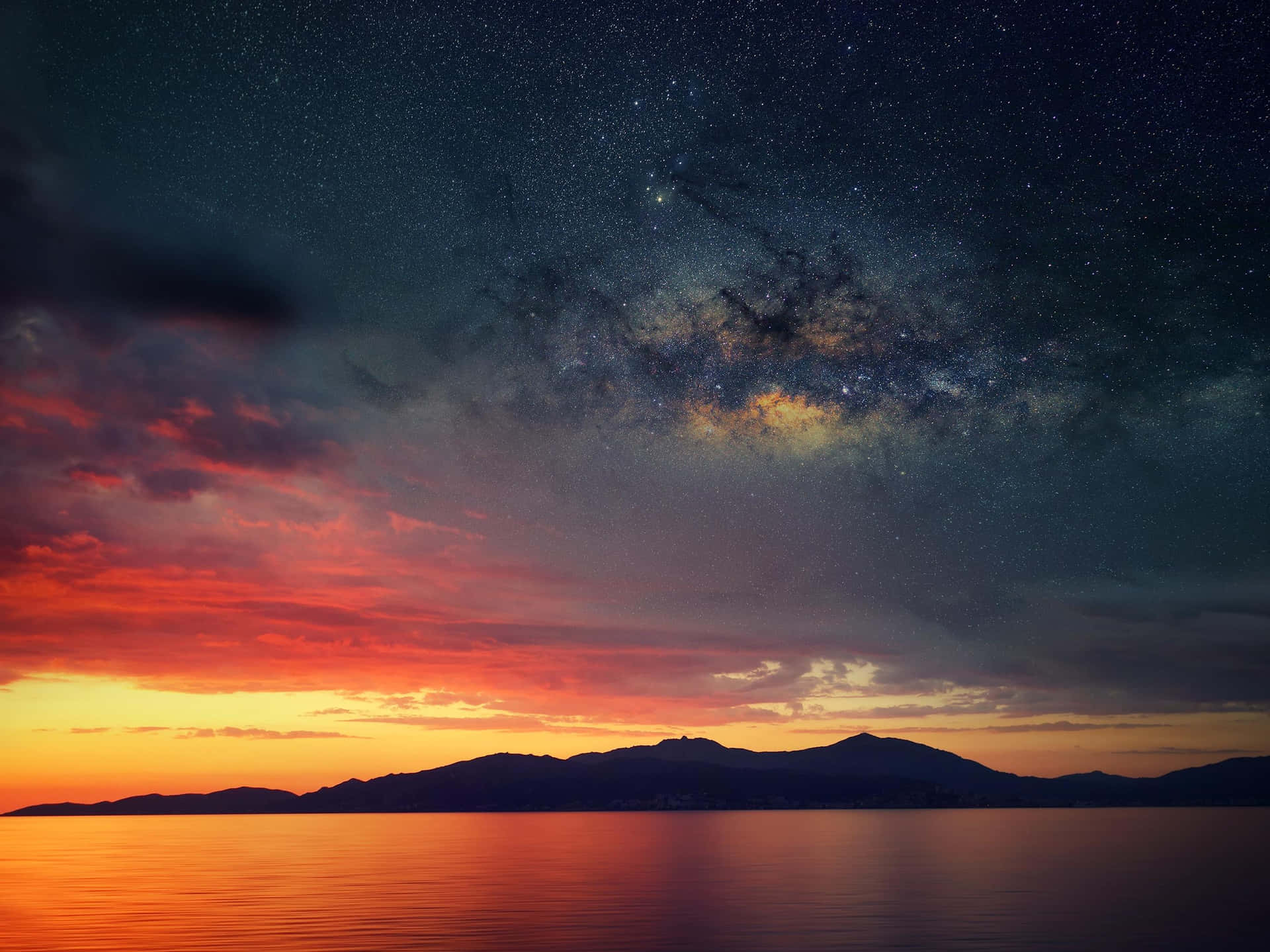 A Beautiful Sunset Over The Ocean And Mountains Background
