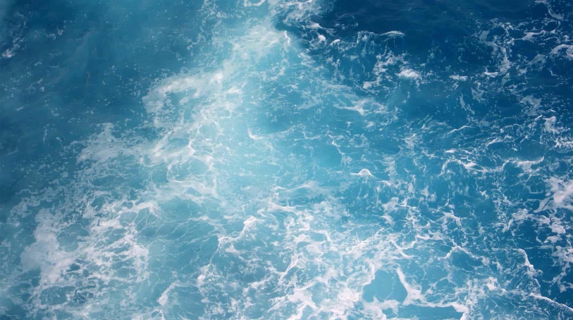 A Beautiful Wave Set Against A Serene Background Background
