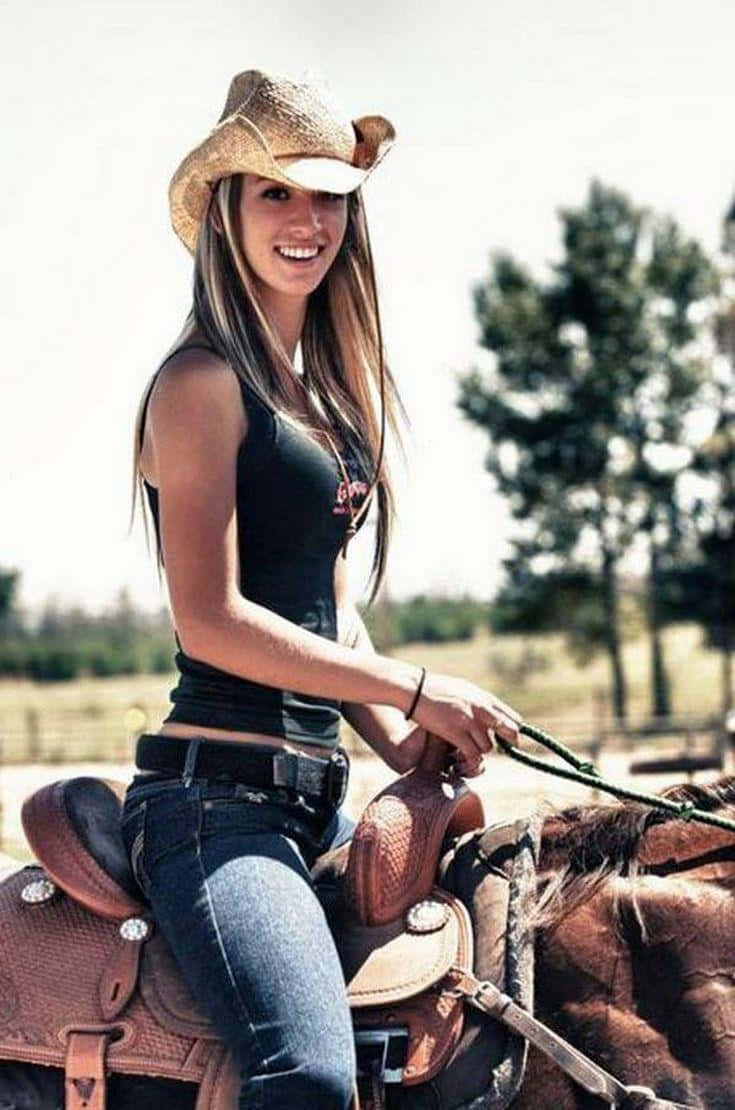 A Beautiful Woman Riding A Horse In A Cowboy Hat Background