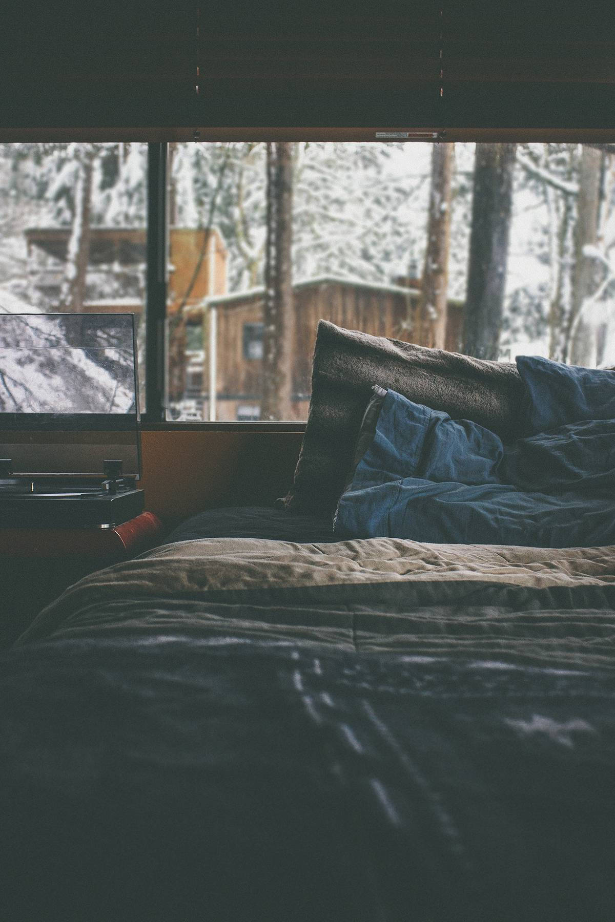 A Bed With A Laptop And A Window