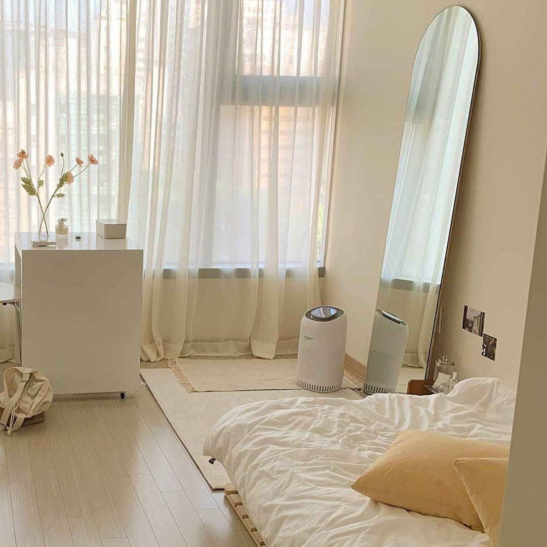 A Bedroom With A Bed, Mirror, And A Fan