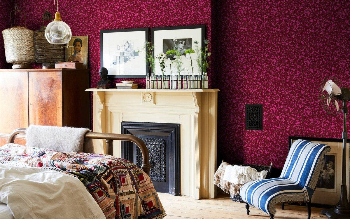 A Bedroom With Red Walls And A Fireplace