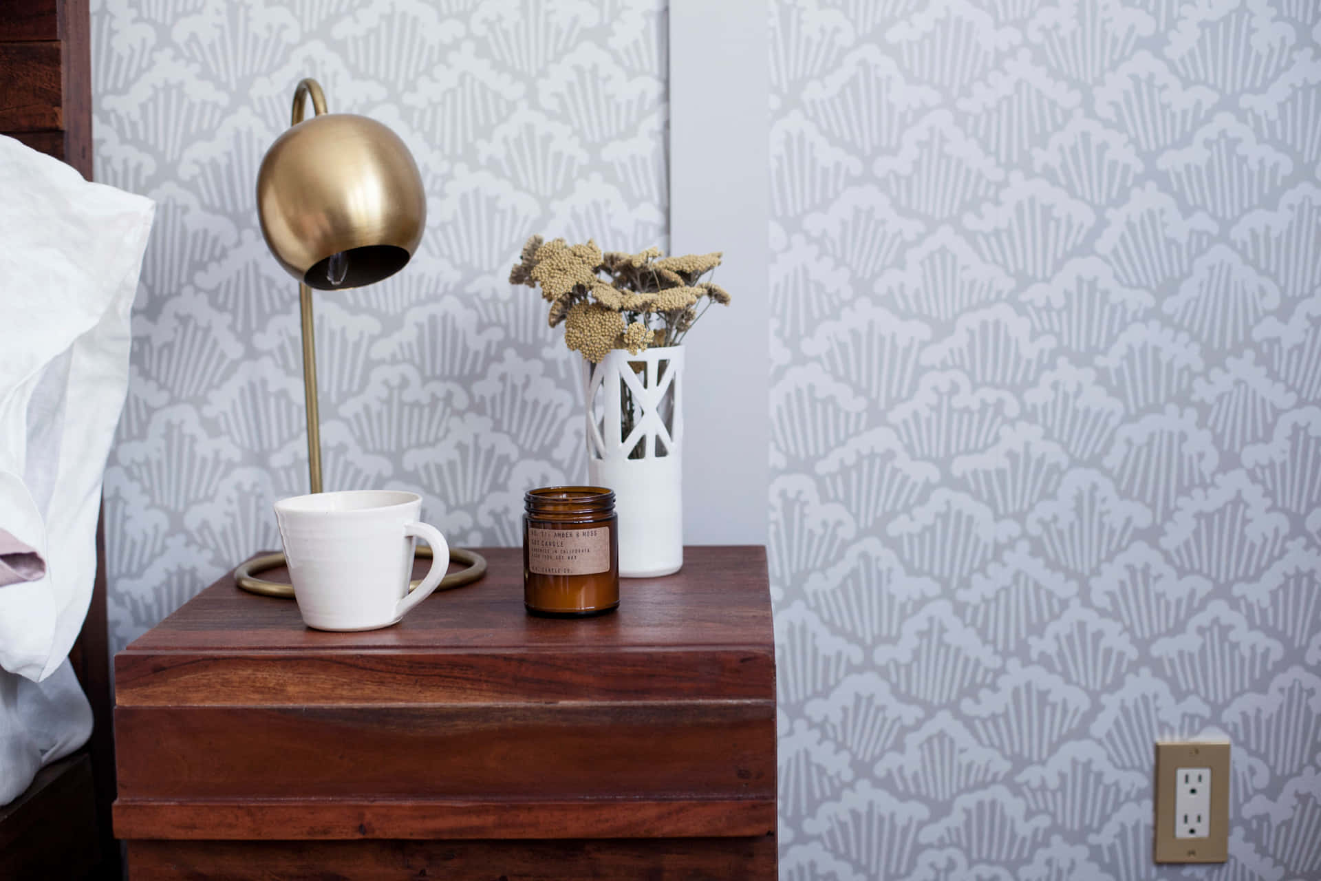 A Bedside Table With A Lamp And A Cup Of Coffee