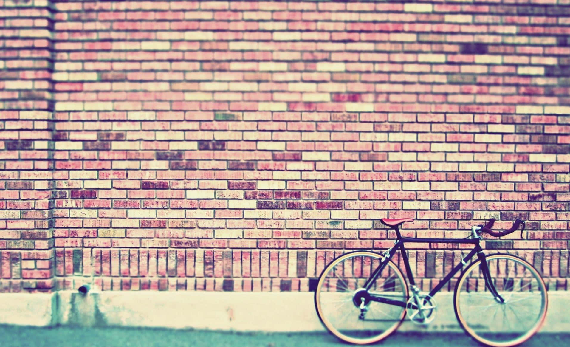 A Bicycle Leaning Against A Brick Wall Background