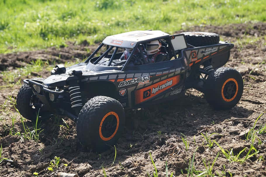 A Black And Orange Rc Off Road Truck In The Field