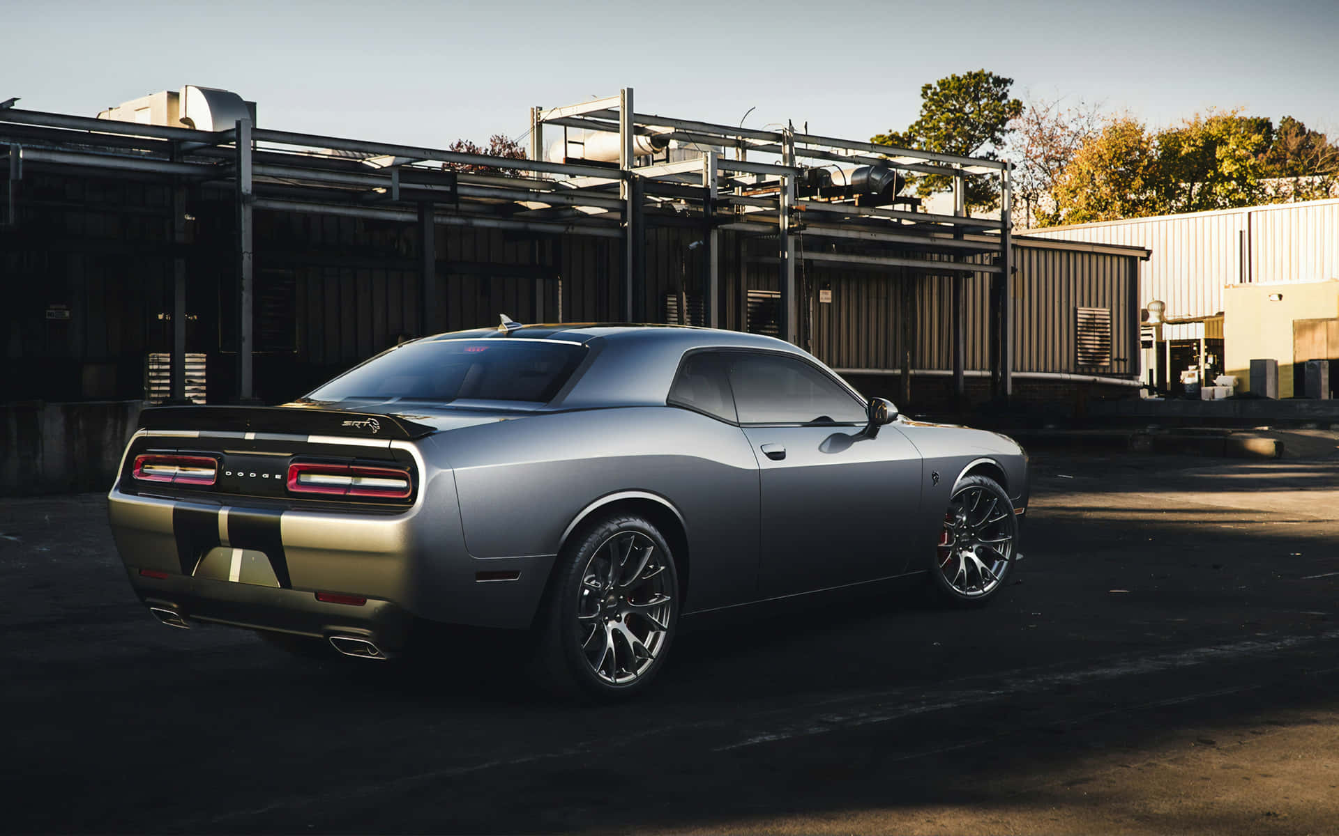 A Black And Silver Car Parked In Front Of A Building Background