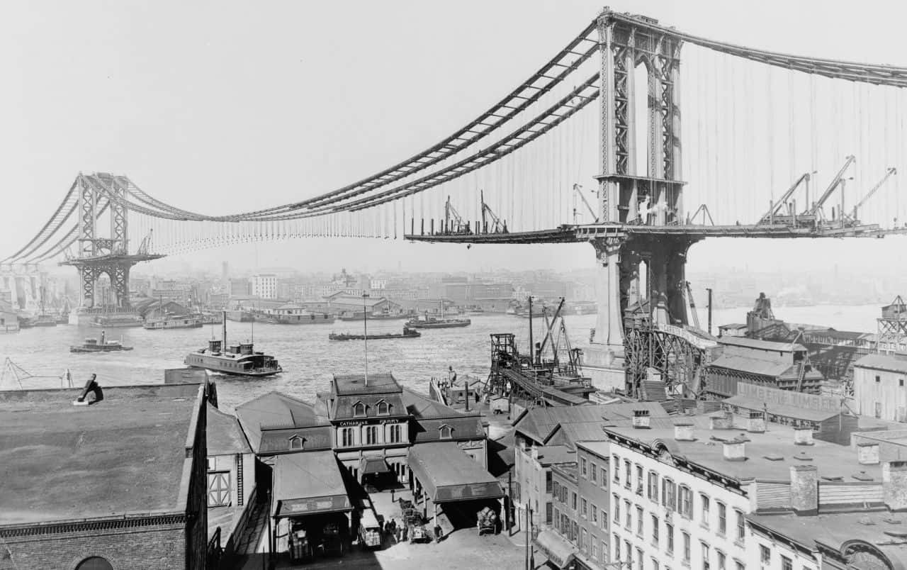 A Black And White Photo Of A Bridge Over A City