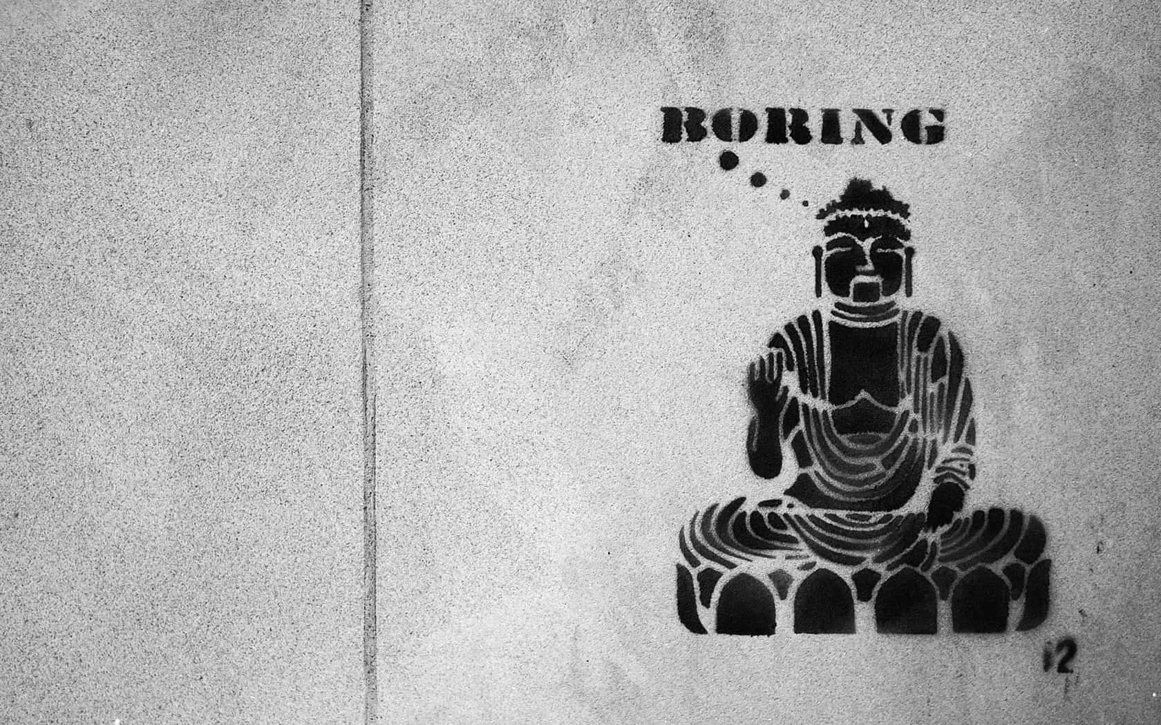 A Black And White Photo Of A Buddha Sitting On A Wall Background