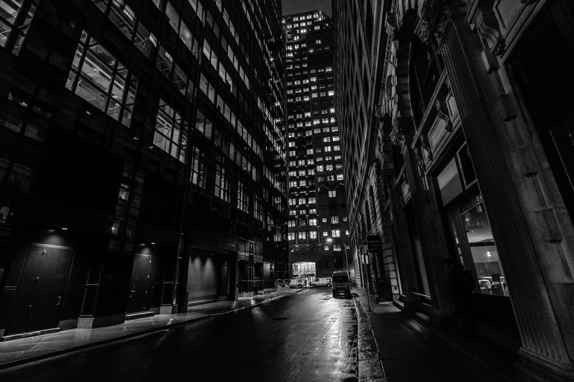 A Black And White Photo Of A City Street At Night Background