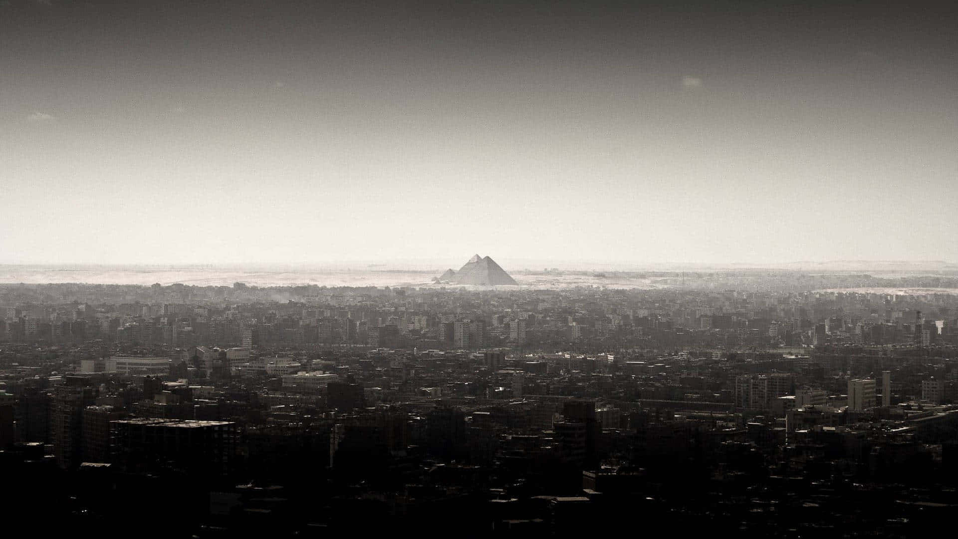 A Black And White Photo Of A City With A Mountain In The Background