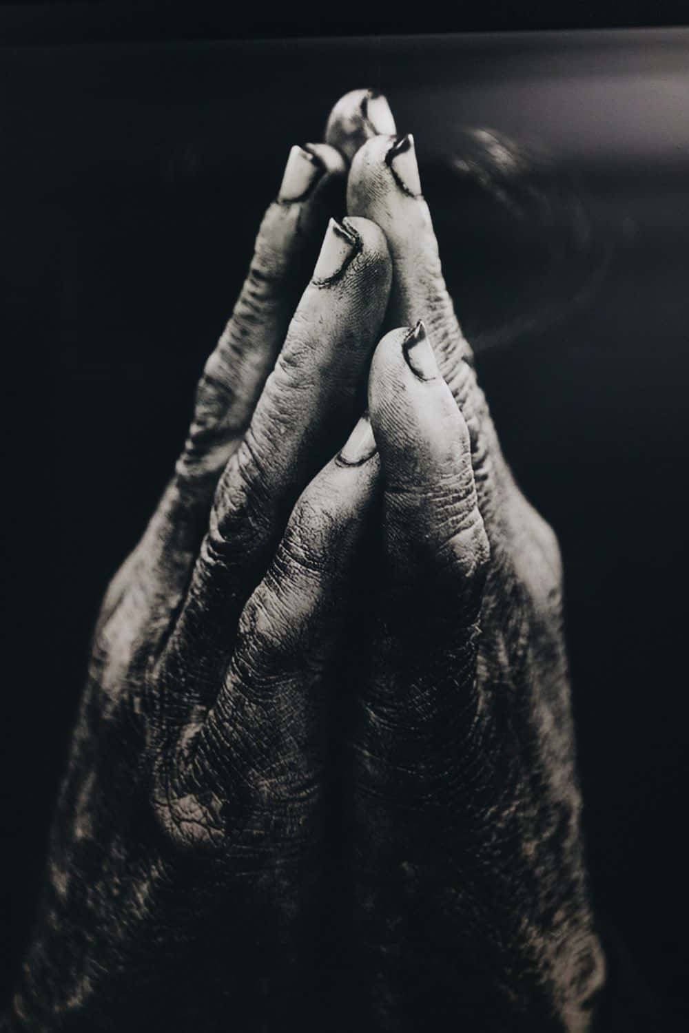 A Black And White Photo Of A Hand Praying