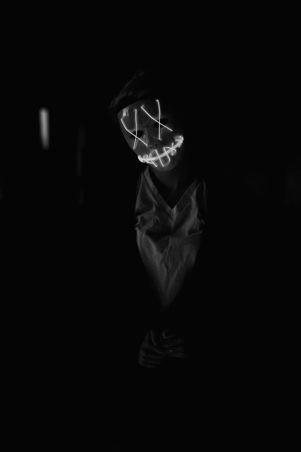 A Black And White Photo Of A Person In A Mask Background