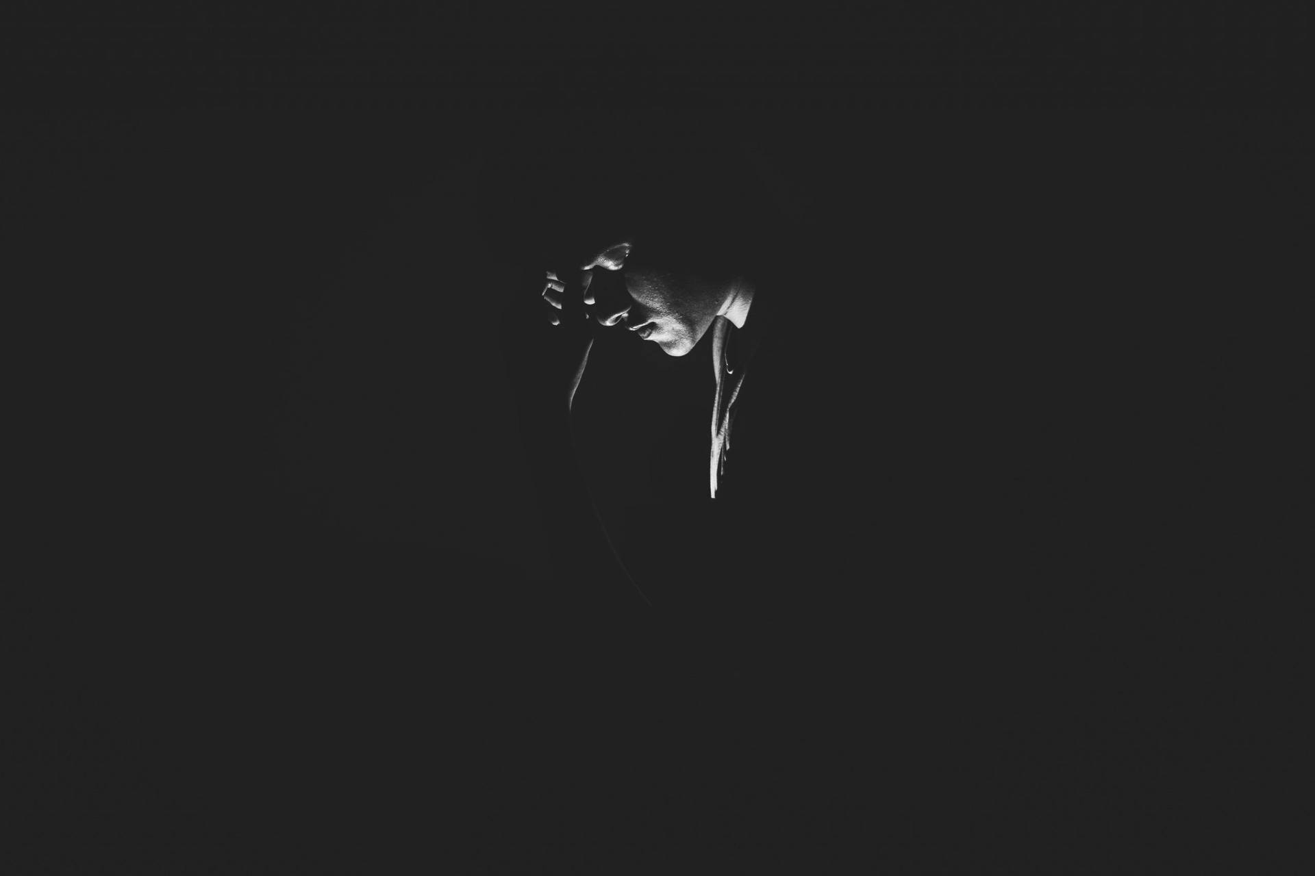 A Black And White Photo Of A Person In The Dark Background