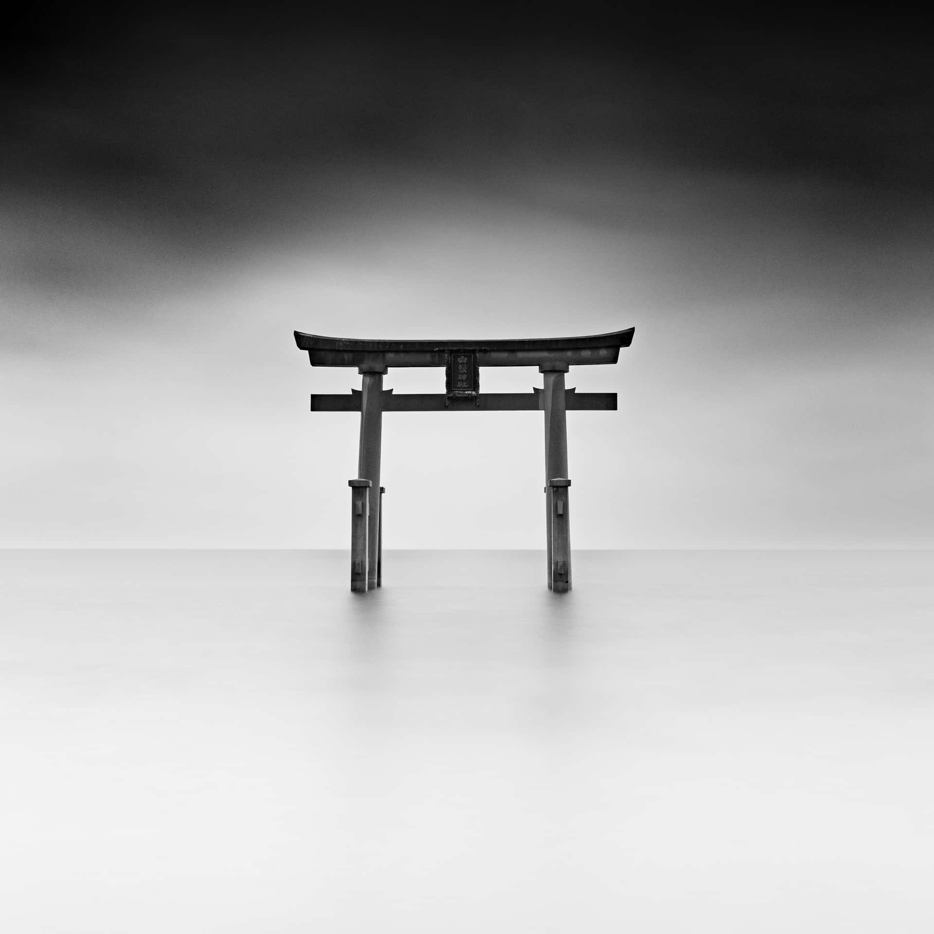 A Black And White Photo Of A Tori Gate In The Water Background