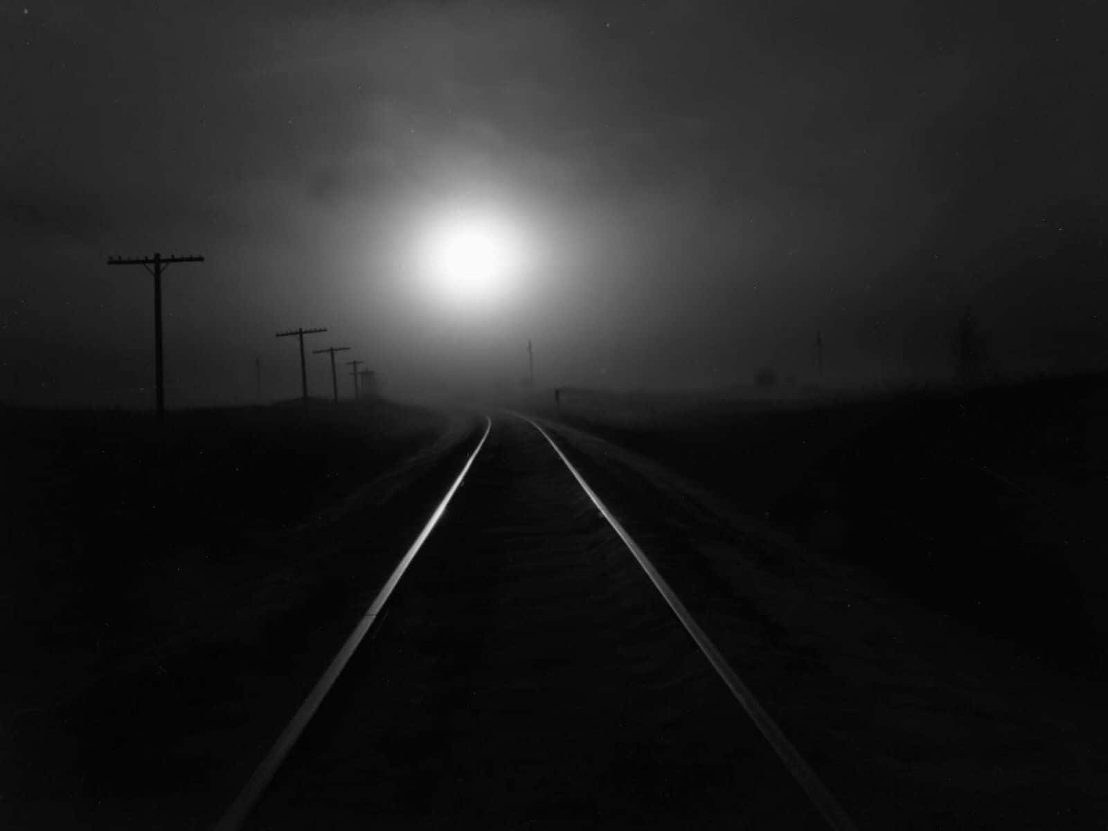 A Black And White Photo Of A Train Track In The Fog Background