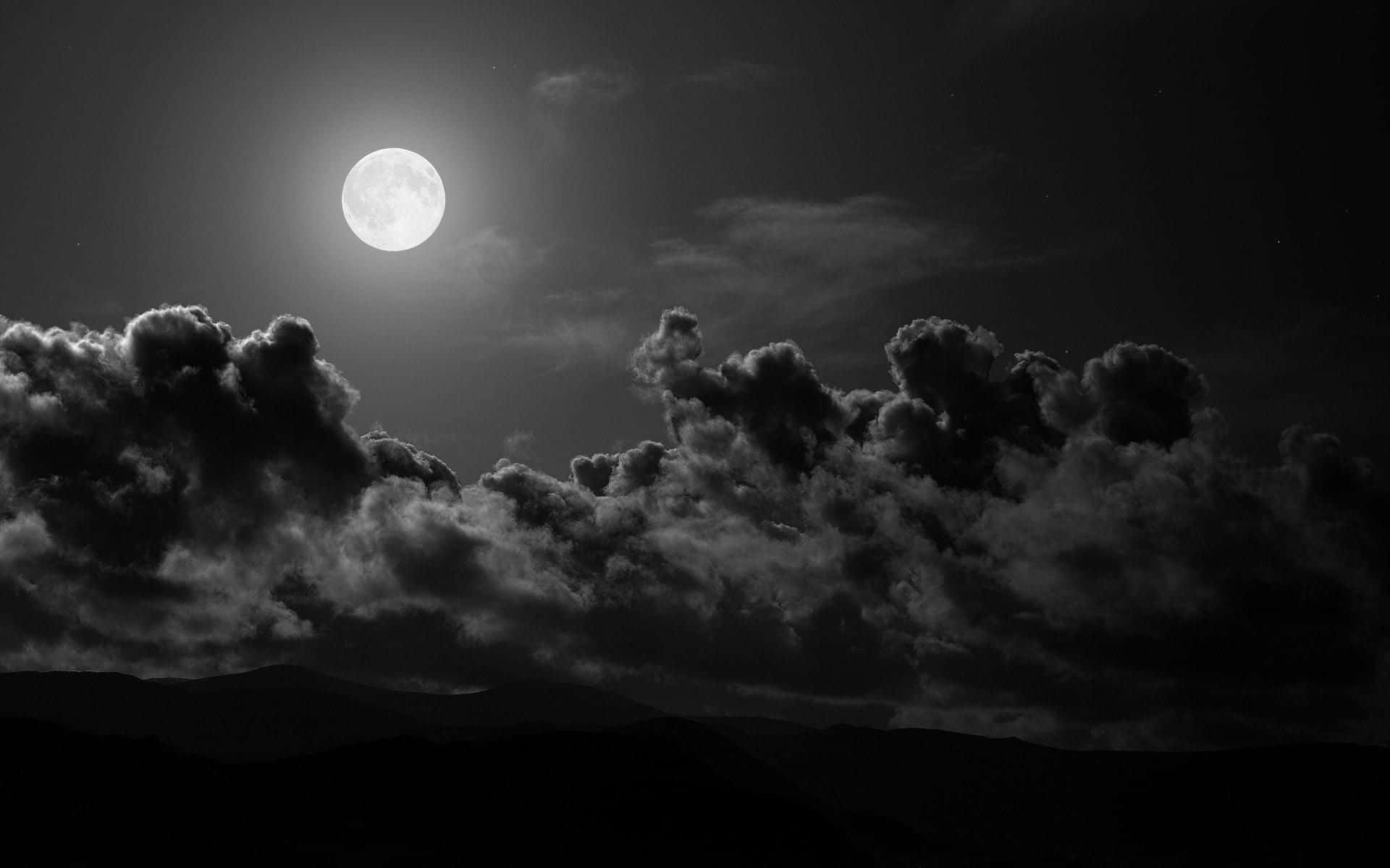 A Black And White Photo Of The Moon And Clouds Background