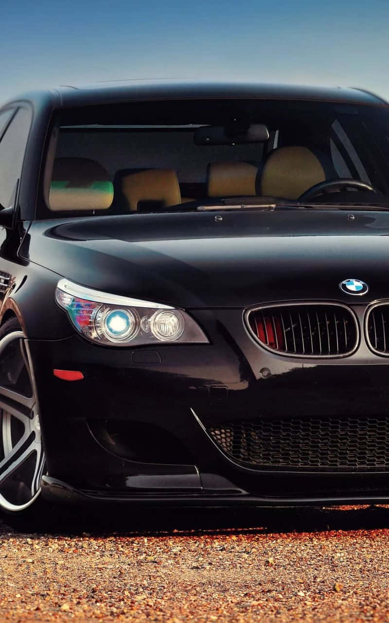 A Black Bmw M Is Featured Alongside An Iphone Background