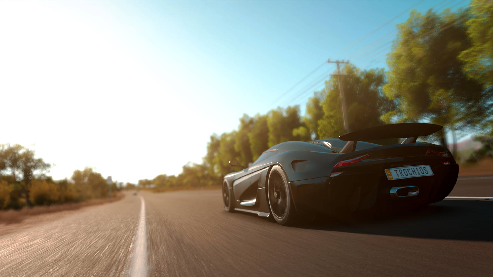 A Black Car Driving Down A Road Background