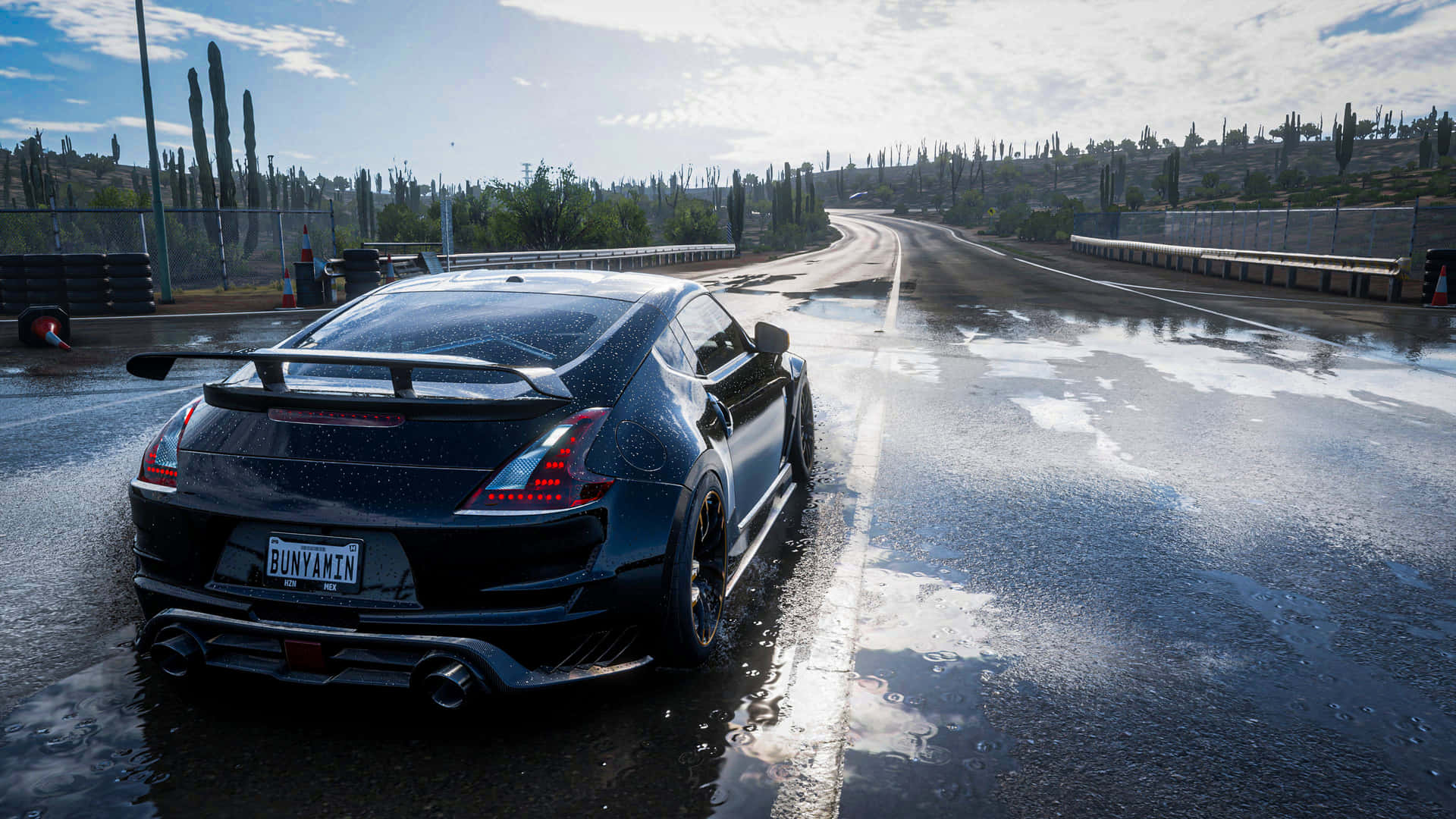 A Black Car Driving Down A Wet Road Background