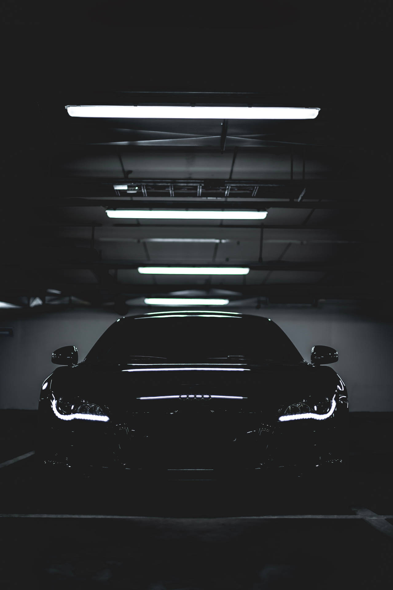 A Black Car In A Dark Parking Garage Background