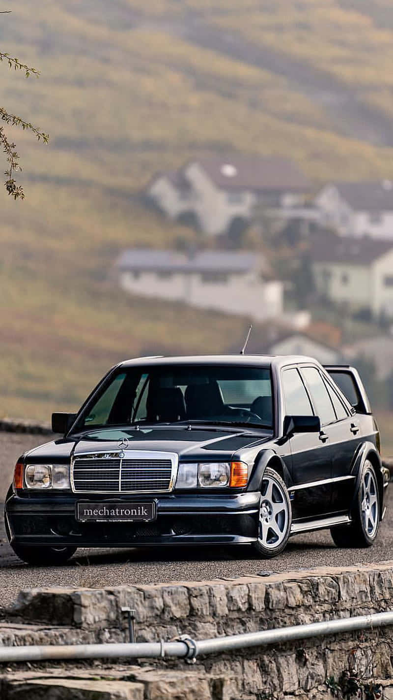 A Black Car Is Parked On A Hillside Background