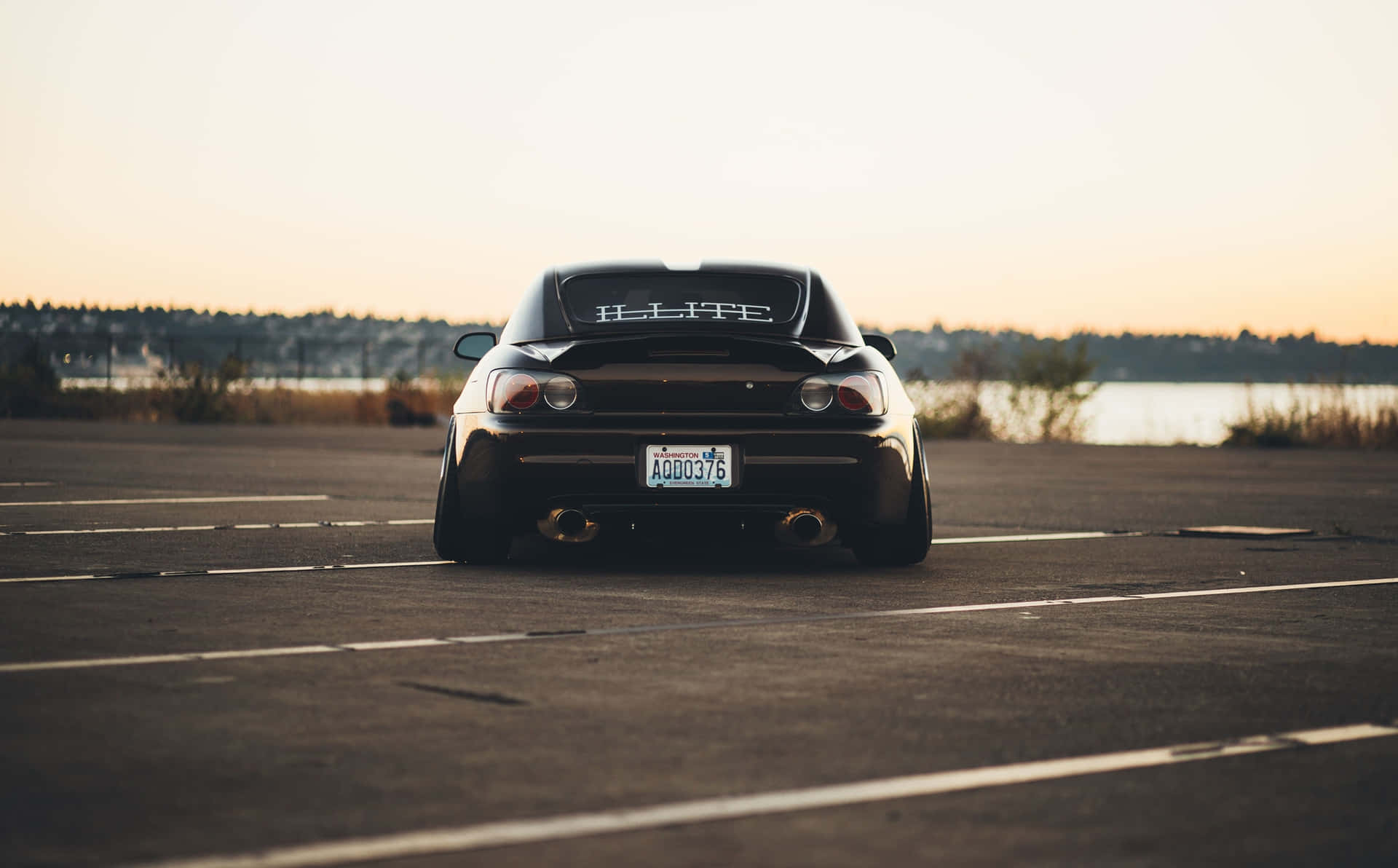 A Black Car Parked In A Parking Lot Background
