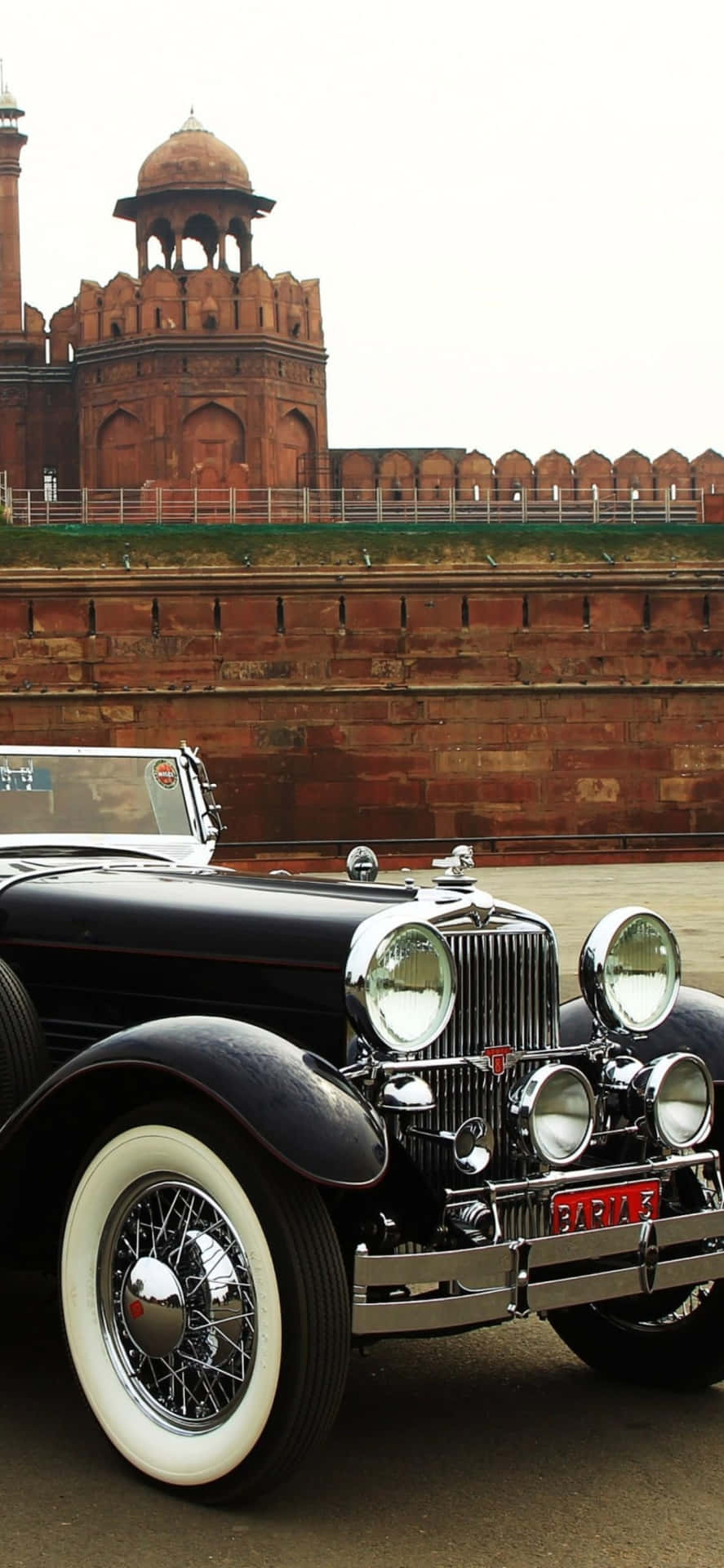 A Black Car Parked In Front Of A Building Background