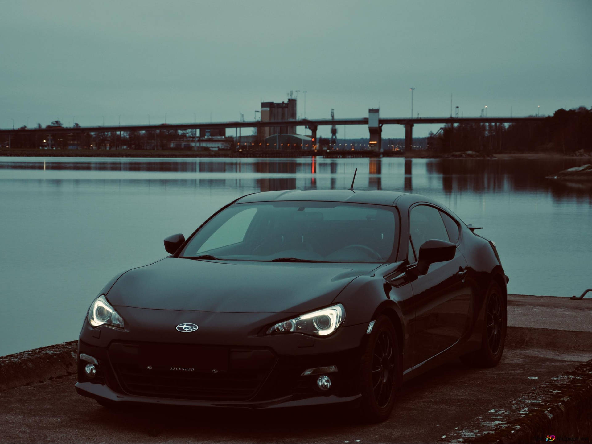 A Black Car Parked Near A Body Of Water Background