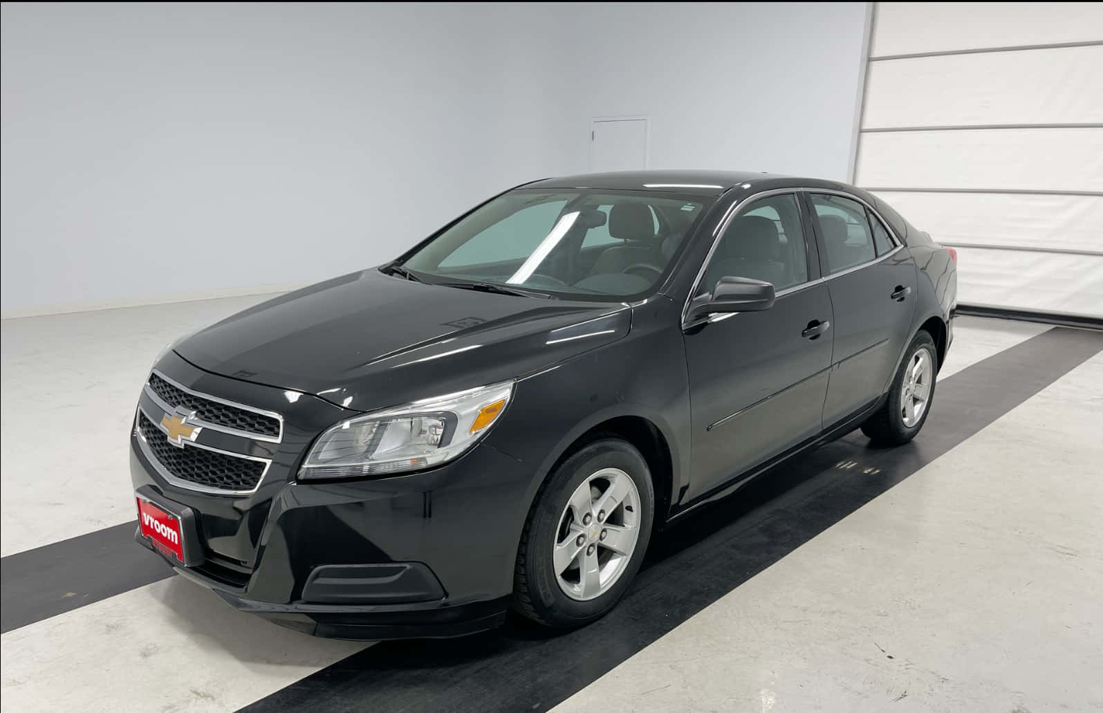 A Black Chevrolet Malibu Is Parked In A Garage Background